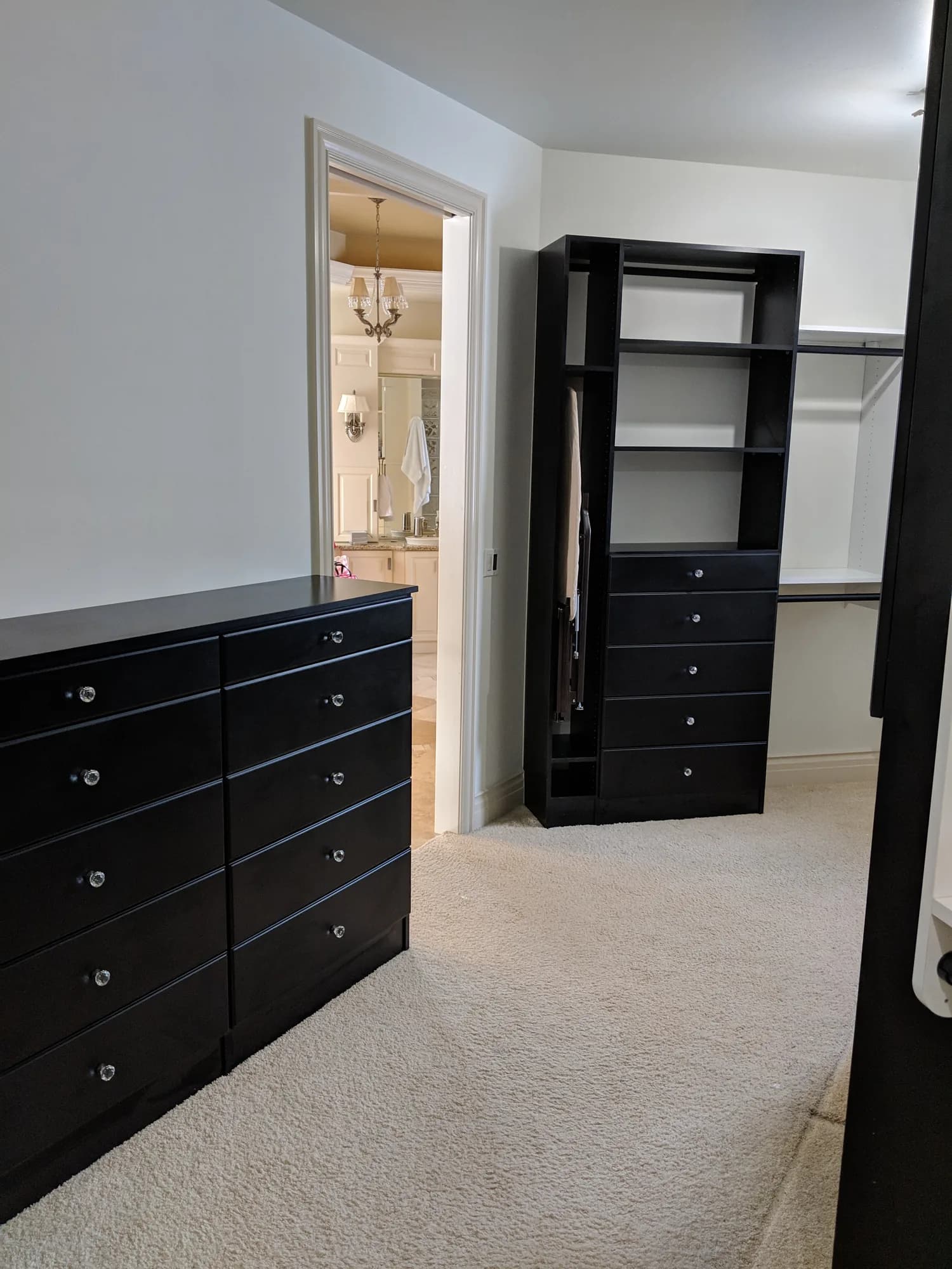 Black built-in drawer chest and tower in a walk-in closet