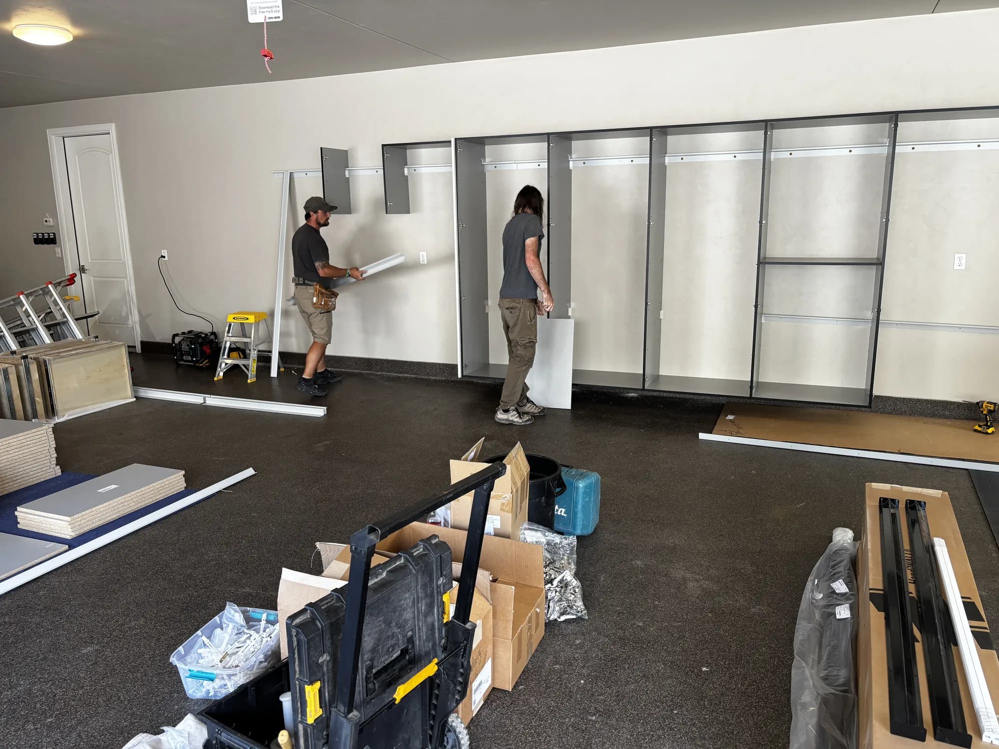 The Closet 1 install team fitting cabinet panels in a new garage