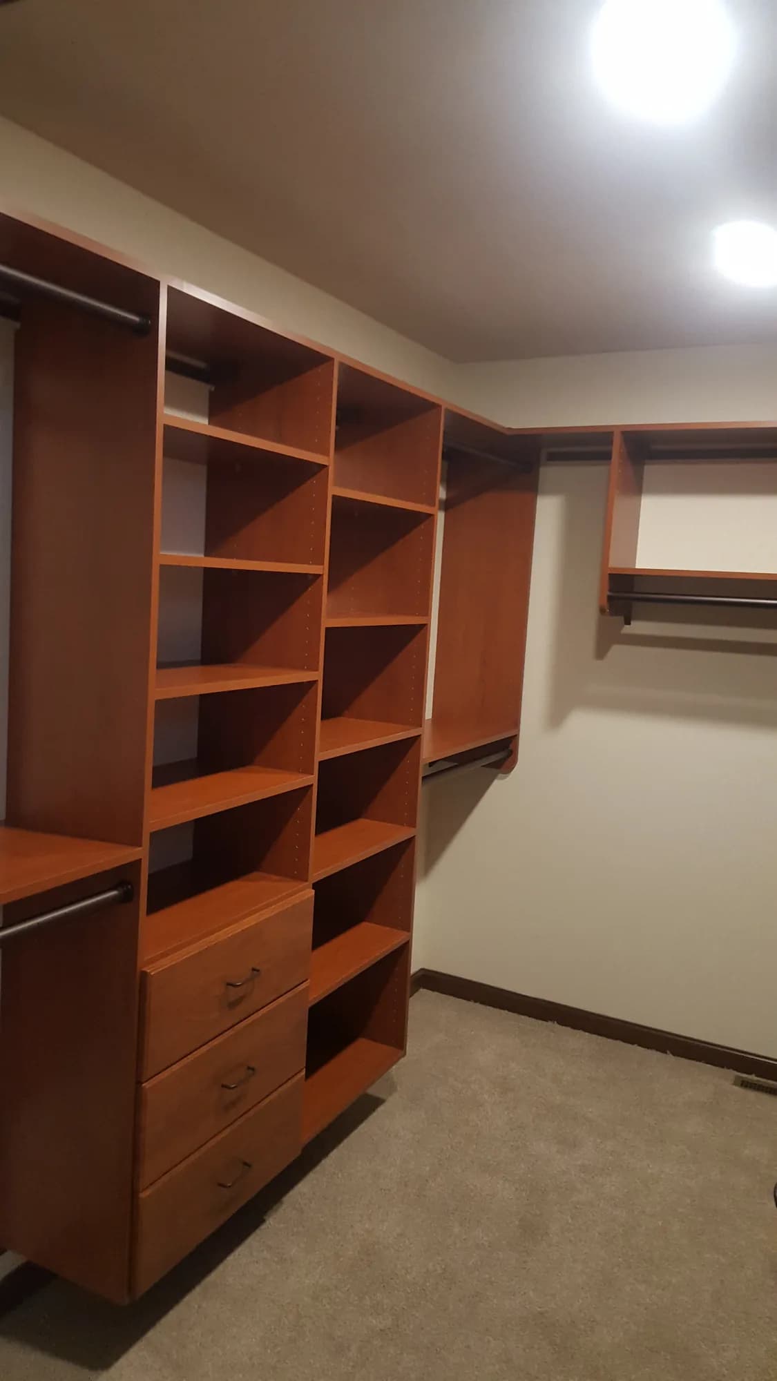 Walk-in closet in a warm cherry finish with open shelving and drawers