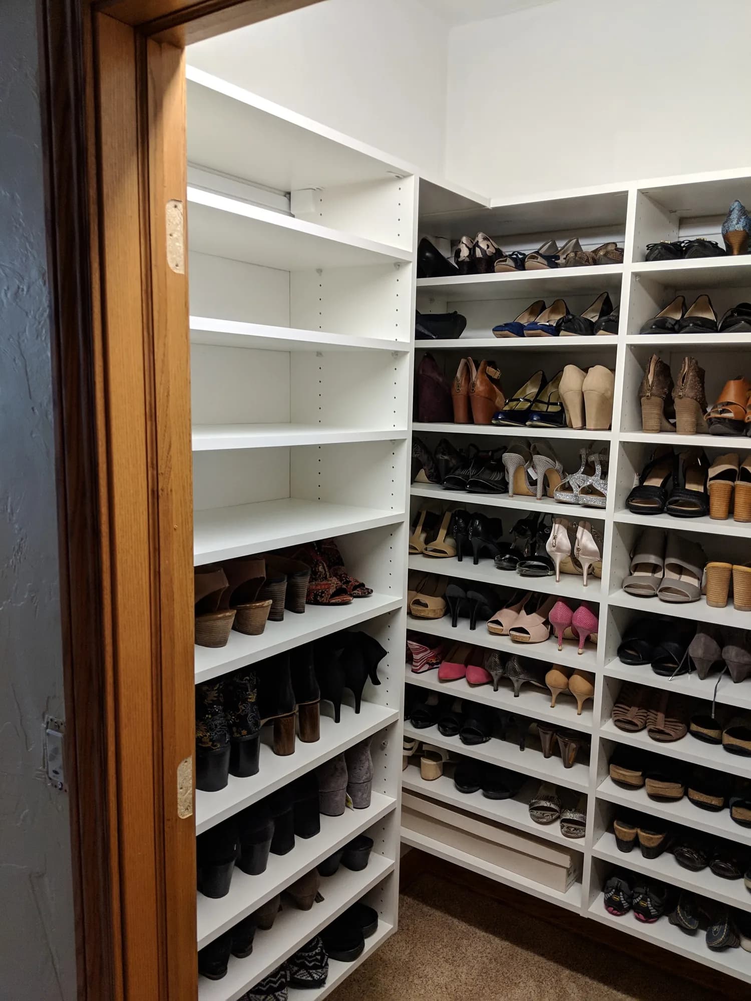 Walk-in closet with a floor-to-ceiling shoe wall and adjustable shelving